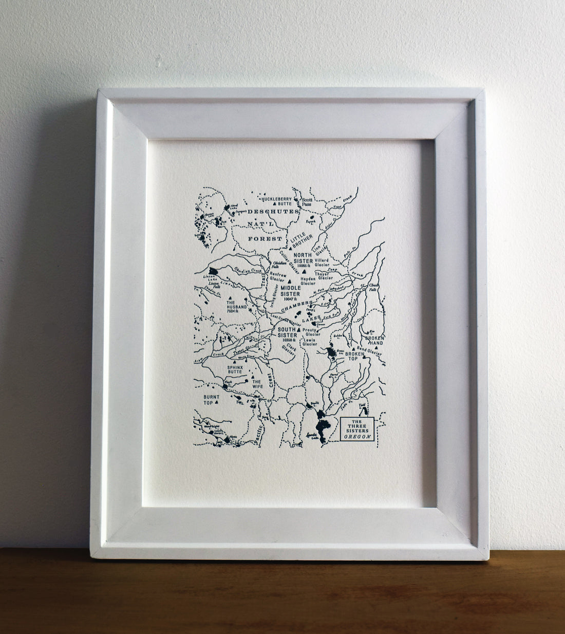 Framed wall art map.  Hand drawn letterpress printed map of the three sisters wilderness and surrounding area.  Prominent mountains, trails, and watersheds are charted.